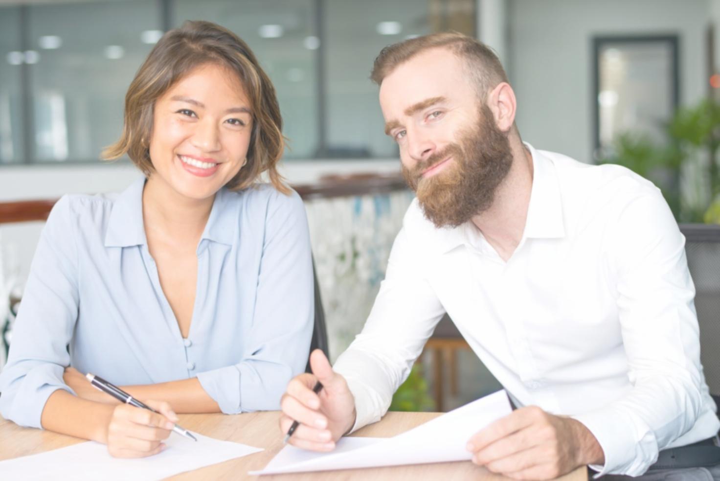 Financial planning consultation showing charts and documents spread across a wooden desk